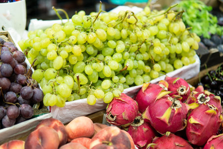 Green grapes and pitahaya on display at traditional food market