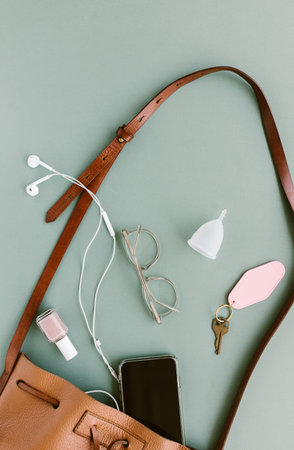 contents of a womans purse spilling out on a mint green backgroundの写真素材