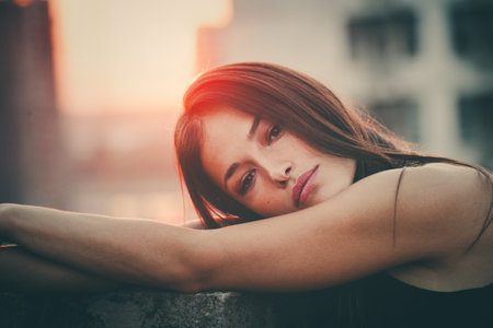 city girl portrait at top of building at sunset closeup