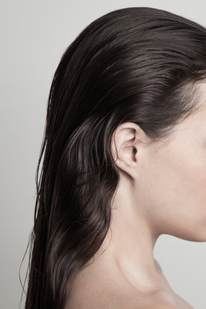 profile of young woman with long dark  wet hair natural beauty conceptの写真素材