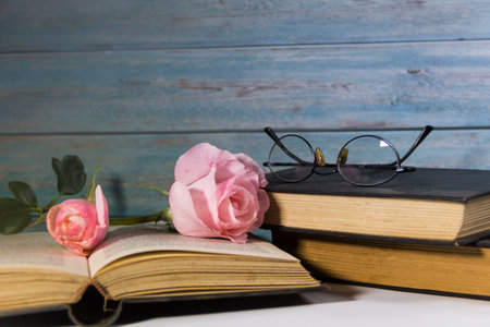 a bouquet of pink roses and books on rustic woodの写真素材