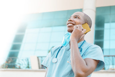 portrait of a cheerful and smiling young african american medical student making a call on a phone. communication concept. with copy space.の写真素材