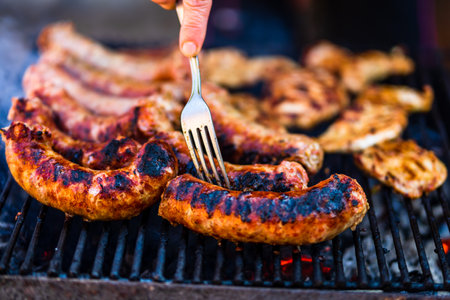 Grilling sausages and pork chops on barbecue grill. BBQ in the gardenの写真素材