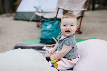 baby playing on the ground at a tent campsiteの写真素材