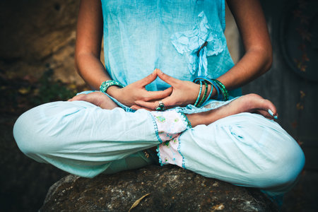 closeup of woman hands and legs in meditative pose practice yoga outdoor shotの写真素材