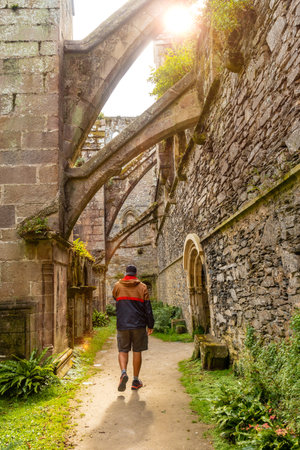 A young man visiting the interior gardens of the Abbaye de Beauport in the village of Paimpol, CÃ´tes-d'Armor department, French Brittany. Franceの写真素材