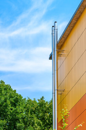 A stainless steel chimney with parts of a colorful facade.