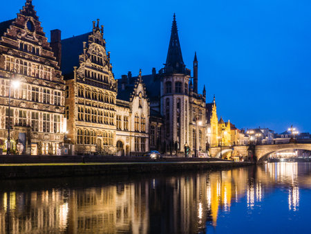 A river reflecting the surrounding buildings at night in Ghent, Belgium.のeditorial素材