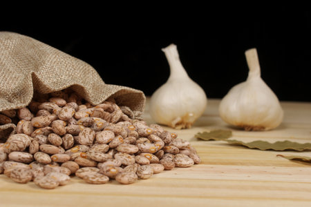Pinto Beans in Burlap Sac With Garlic and Bay Leaves in Backgroundの写真素材