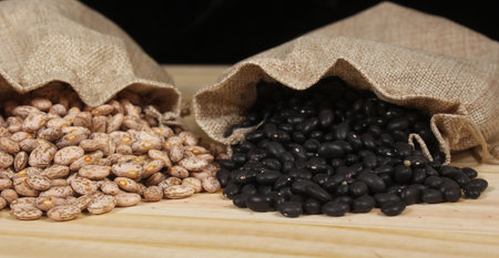 Pinto Beans and Black Beans in Burlap Bag on Wooden Background