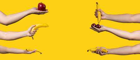 hands with fruits on yellow backgroundの写真素材