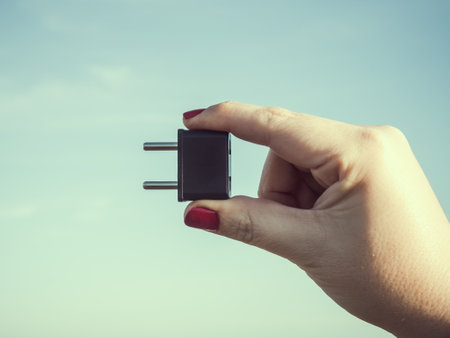 Woman holding a black plugの写真素材