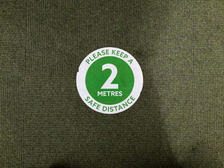 Floor sign in a store informing customers to keep to the 2m safe social distance, Covid 19 pandemic...