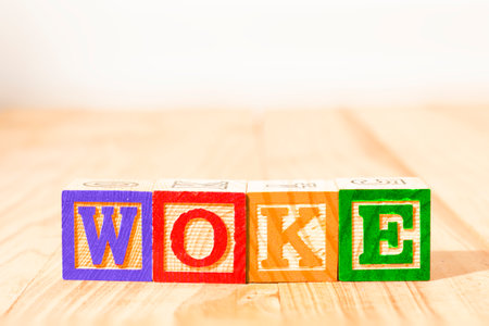 Spectacular wooden cubes with the word WOKE on a wooden surface.の写真素材