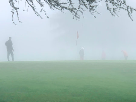 Golfer on Putting Green in Crans Sur Sierre Golf Course with Fog in Crans Montana in Valais, Switzerland.の写真素材