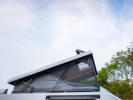 Camper van with tent on roof on dealership showroomの写真素材