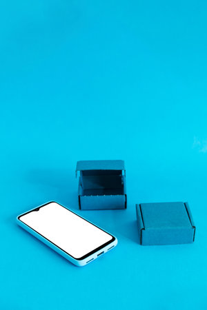 Isometric view of mobile phone and two boxes on light blue background. Shopping online.の写真素材
