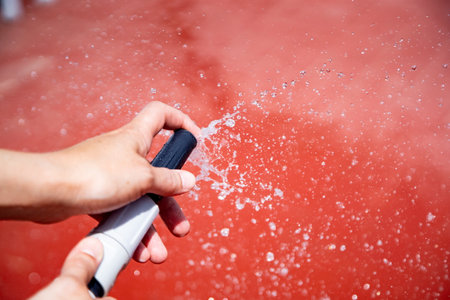 Meek with water hose wetting terrace floor.