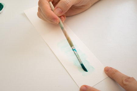 woman painting with watercolors in her studio at homeの写真素材