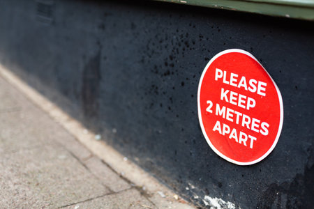 Floor sign in a store informing customers to keep to the 2m safe social distance, Covid 19 pandemic restrictionsの写真素材