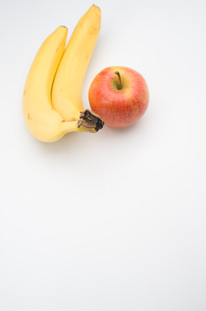 fresh and healthy fruits on a white surface - apple and bananaの写真素材