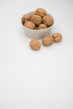 White bowl with Stack Walnuts isolated on a white background with free space