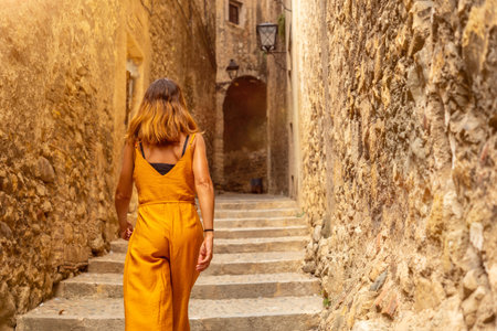Girona medieval city, a young woman climbing the stairs of the streets of the historic center, Costa Brava of Catalonia in the Mediterranean. Spainの写真素材