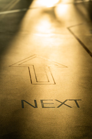 letter next and arrow on the ground for abstract concept, selective focus.の写真素材