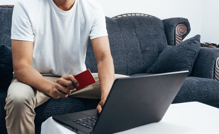Close up unrecognizable person holding a credit card using a laptop. Concept buy online in online shop.の写真素材