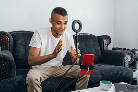 hispanic young man make a video with a phone. influencer blogger man talk on stream video. content...