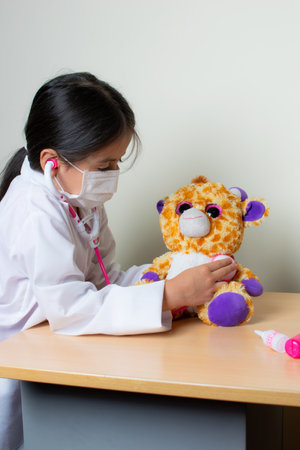 beautiful Colombian girl plays pediatrician doctor examining toysの写真素材