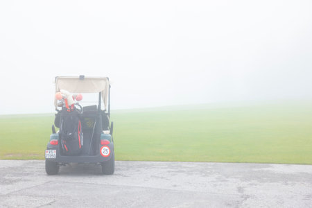 Golf Cart with Golf Bag in Crans Sur Sierre Golf Course with Fog in Crans Montana in Valais, Switzerland.の写真素材