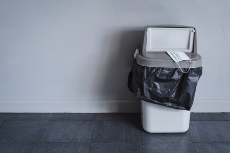 A used protective facemask scattered and unwell-managed in the buildingの写真素材