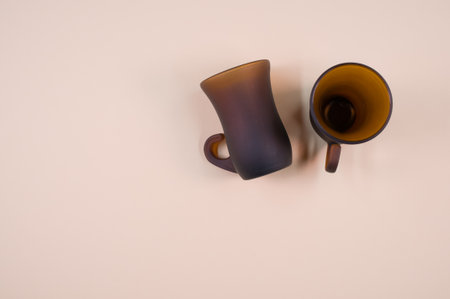 A closeup of a brown glass teacup on a beige-colored surface with text spaceの写真素材