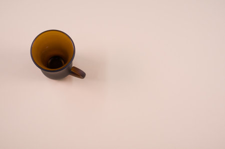 A closeup of a brown glass teacup on a beige-colored surface with text spaceの写真素材