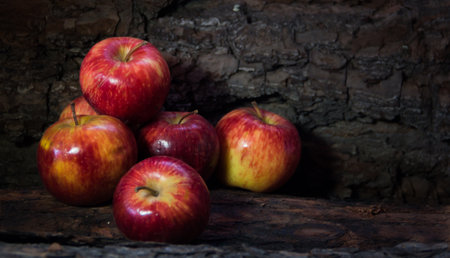 a group of red apples on a rustic background with trunk textureの写真素材