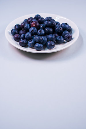 view of the sweet tasty blueberries on a plate on a white backgroundの写真素材