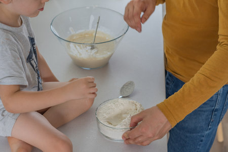 young man making homemade bread with his son in his home kitchen