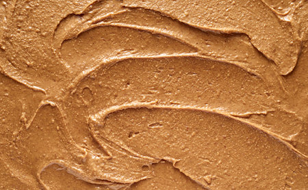 Closeup top view of full frame textured background of yummy soft peanut butter