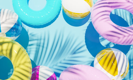 colorful summer background with floats and beach balls with palm tree shadows. 3d render