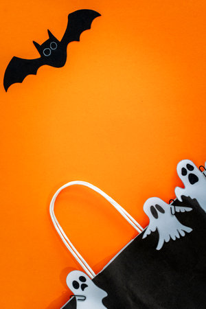 Halloween sale banner with bat, ghost and bag on orange background.の写真素材