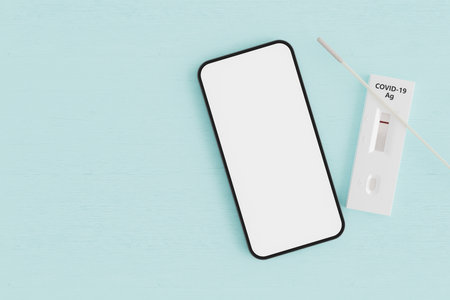 mock-up of mobile phone with negative antigen test on wooden table. COVID passport concept,...