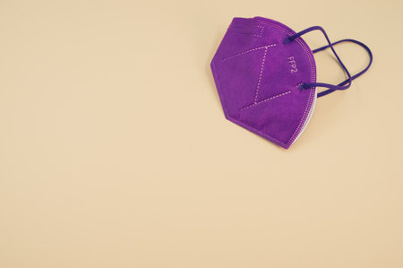Isolated FFP2 respiratory mask on a beige background wit text spaceの写真素材