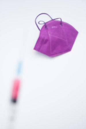 Isolated FFP2 respiratory mask with syringe on a white background wit text spaceの写真素材