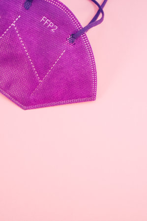 Isolated FFP2 respiratory mask on a pink background wit text spaceの写真素材