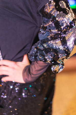Christmas lights in the city, Caucasian blonde girl dressed in black detail of the sequins and...