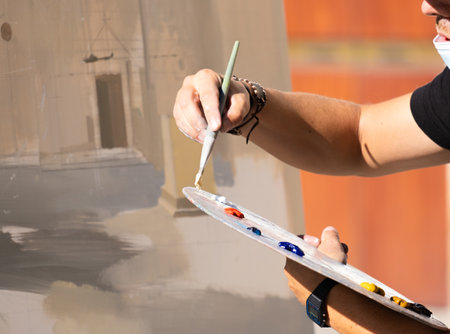 Detail shot of the paintbrush and palette of a male artist. Concept painting outdoors, artists outdoorsの写真素材