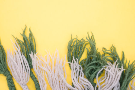 hand knitted soft wool on a yellow background with copy spaceの写真素材