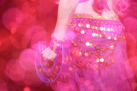 Belly Dancer wearing purple dance costume close up with colorful bokehの写真素材