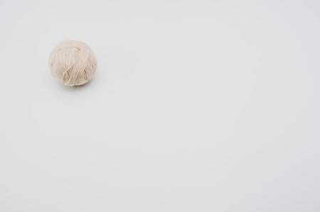 A vertical shot of isolated beige yarn on a white background with text spaceの写真素材